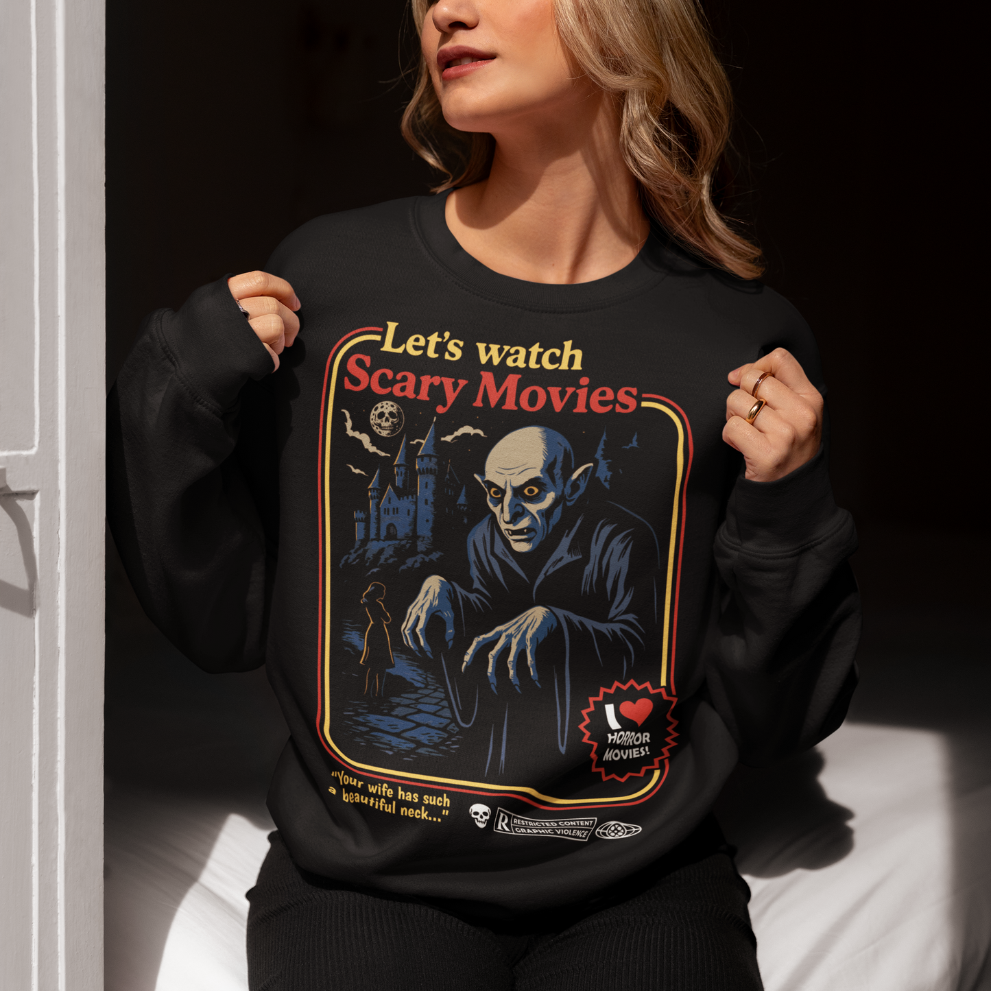 Stay warm with a touch of vintage terror in this Nosferatu-inspired horror shirt. Designed in a retro poster style, it features a classic vampire creeping through a moonlit scene, complete with bold colors, distressed detailing, and nostalgic typography that captures the eerie charm of early silent-film monsters. This shirt is a must-have for horror lovers, gothic aesthetics fans, and anyone who appreciates timeless spooky cinema.