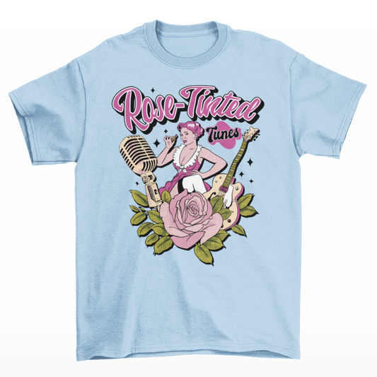 Light blue t-shirt with a woman putting on lipstick surrounded by a rose, a microphone and a guitar with text above "ROSE-TINTED TUNES".