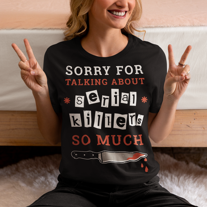 The t-shirt features a humorous and slightly self-deprecating message that reads "SORRY FOR TALKING ABOUT SERIAL KILLERS SO MUCH". The text is printed in bold, white and red letters on a solid-colored background, creating a striking contrast that catches the eye. The design is simple yet effective, making it perfect for anyone who has a penchant for true crime and likes to engage in conversations about serial killers.