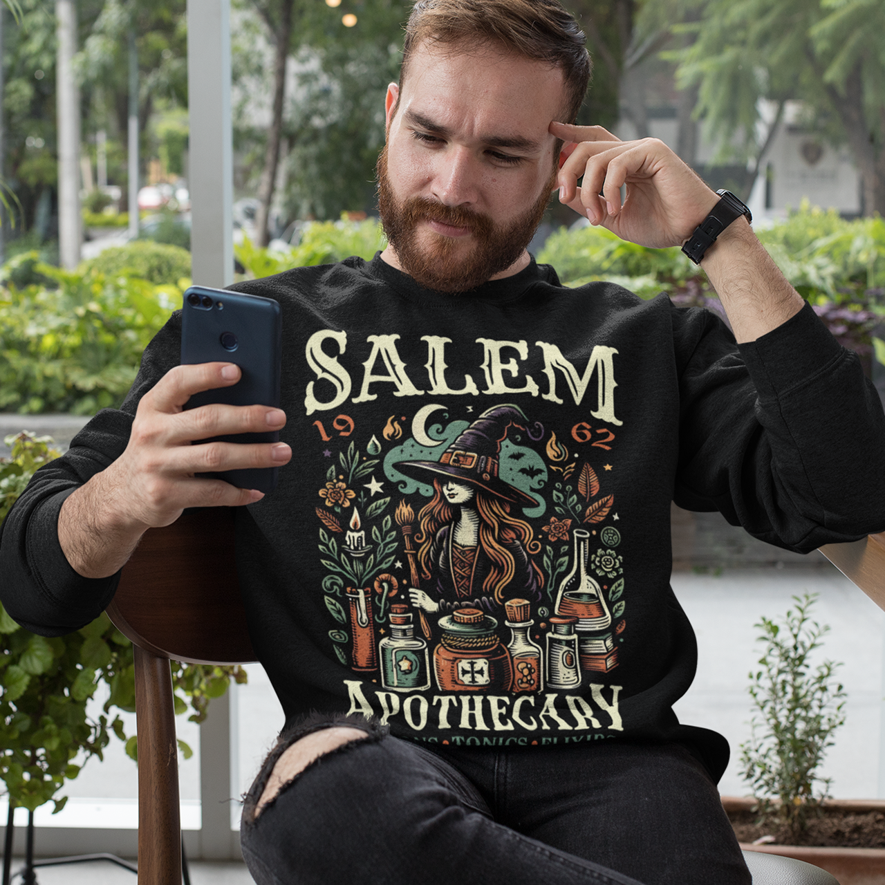 Black sweatshirt of a Witch with potions and text SALEM APOTHECARY.