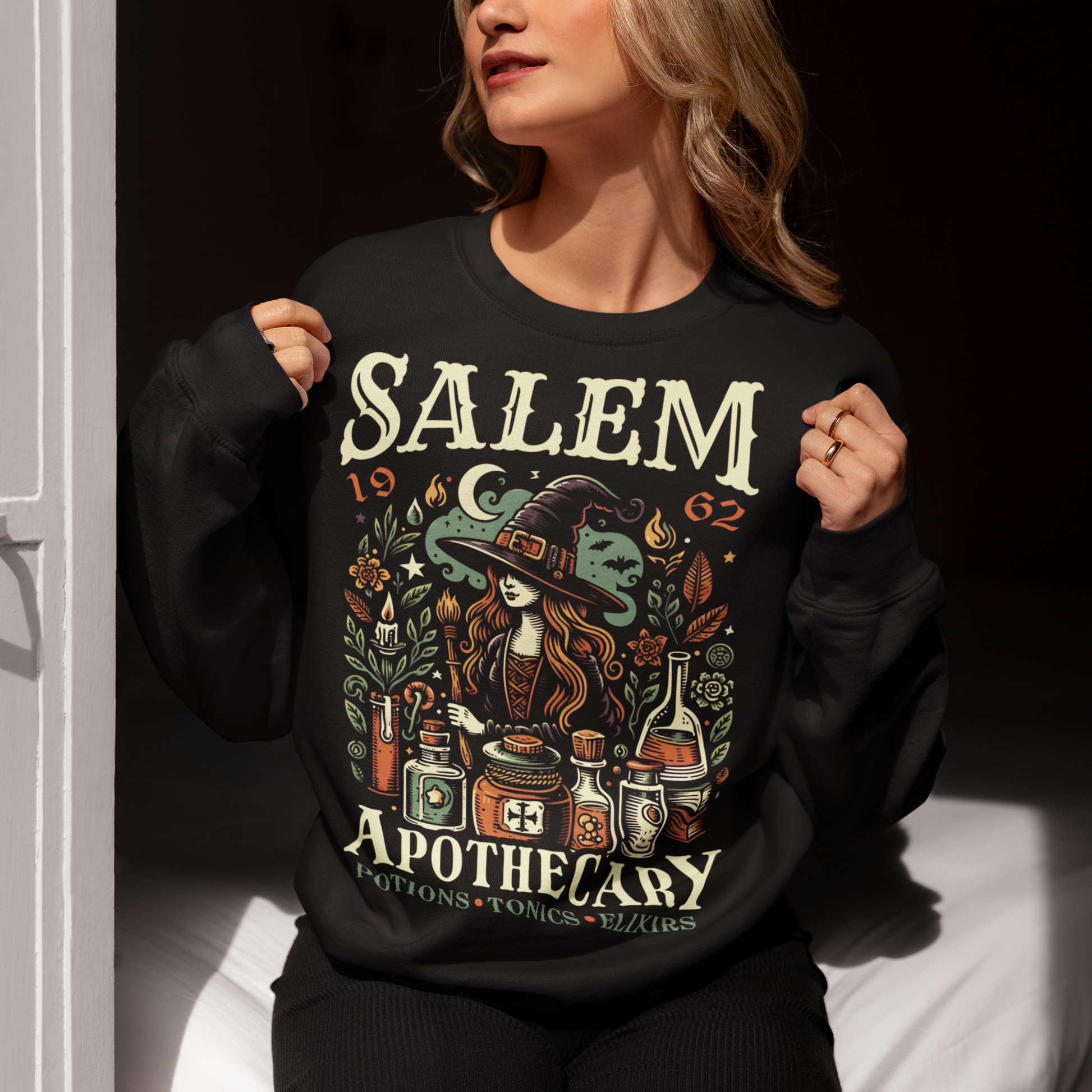 Black sweatshirt of a Witch with potions and text SALEM APOTHECARY.