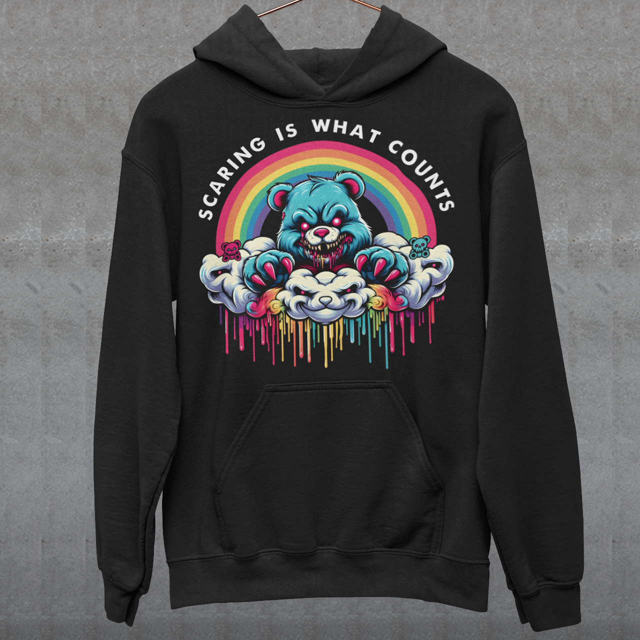 Black hoodie of scary bear on a cloud with a rainbow with text above "SCARING IS WHAT COUNTS".