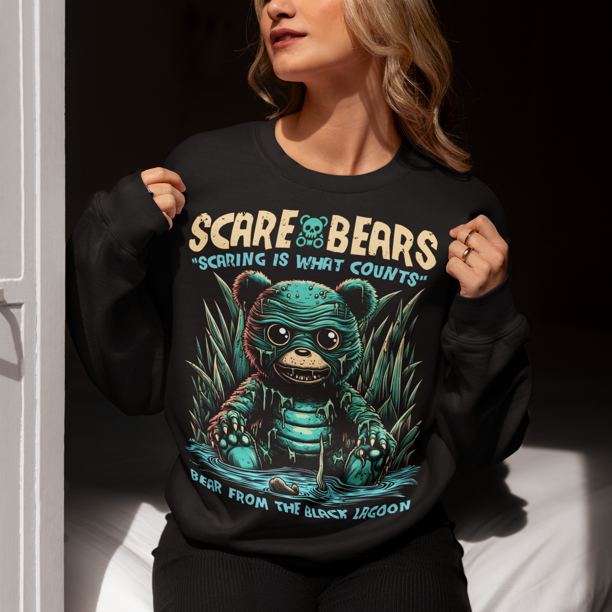 Black sweatshirt of a creature from the black lagoon bear sitting in a swamp with text above "SCARE BEARS". "Text below "BEAR FROM THE BLACK 
