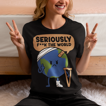 Black t-shirt featuring a funny cartoon Earth character with bandages, crutches, and an angry face flipping the middle finger. Above the character is the text “Seriously F**k The World” in bold lettering. The design uses bright blue and green Earth colors against a black shirt for a dark humor, sarcastic graphic tee style.