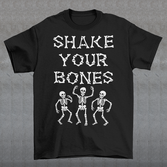 Black t-shirt featuring bold distressed lettering reading “SHAKE YOUR BONES” above three dancing skeletons. The vintage-inspired graphic uses white artwork on a black background, creating a spooky gothic look with dark humor. Perfect for Halloween, skeleton lovers, goth fashion fans, spooky season, parties, concerts, and anyone who likes their wardrobe with a little skeletal attitude.