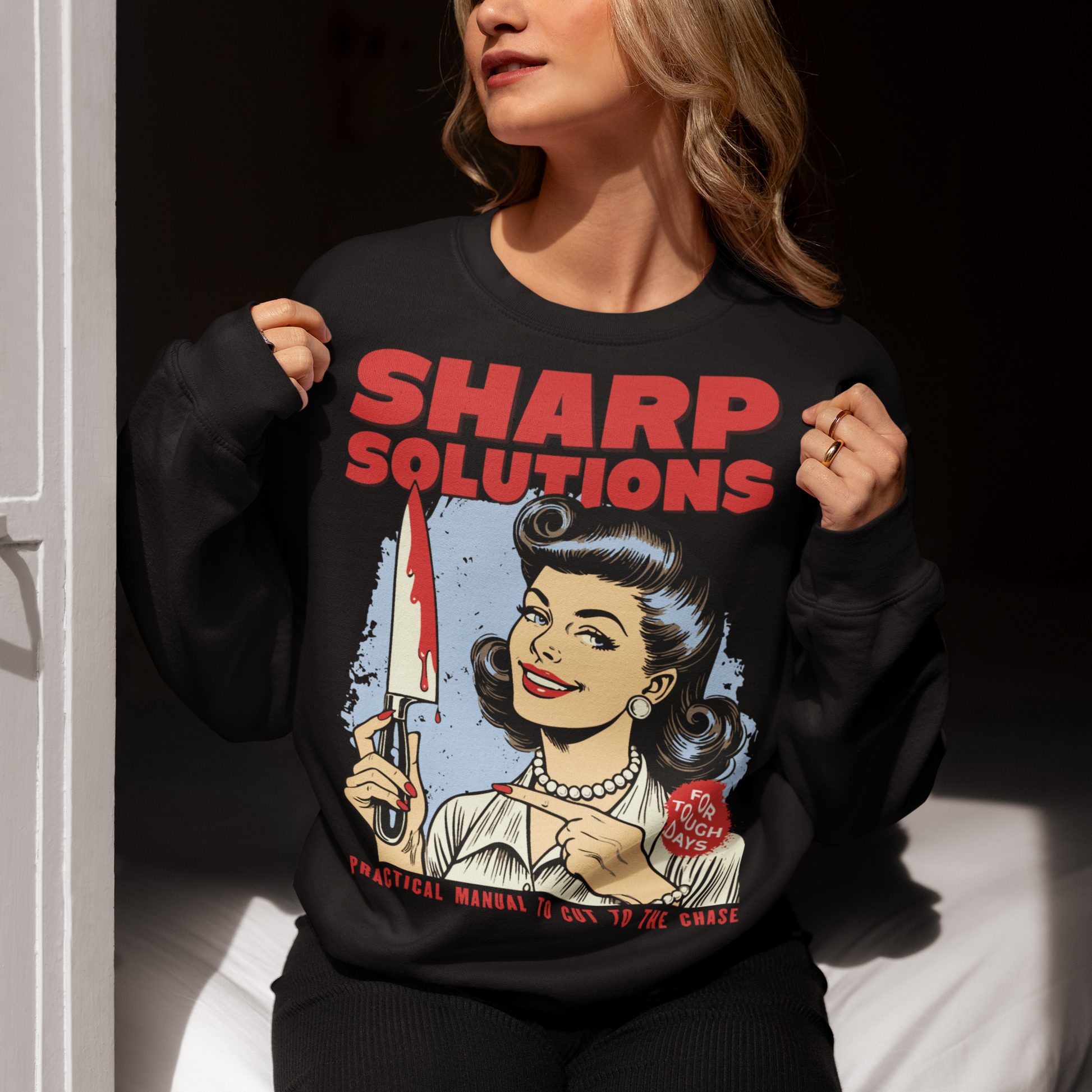 Slice through the stress of everyday life with this bold and cheeky “Sharp Solutions” retro-style Sweatshirt. Designed in a classic vintage aesthetic, it features a 1950s housewife confidently holding a dripping knife with a charming smile, paired with tongue-in-cheek text that adds the perfect dose of dark humor. Ideal for fans of edgy throwback art, sarcastic designs, and quirky graphic tees, this shirt makes a standout gift and a fun conversation starter wherever you wear it.