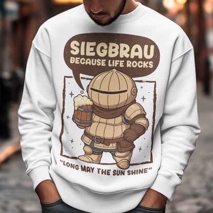 White sweatshirt featuring a cute, chibi-style armored knight Siegmeyer of Catarina holding a frothy beer mug. Above the character, bold text reads “Siegbrau because life rocks,” with smaller text below saying “Long may the sun shine.” The design has a playful fantasy theme with soft brown tones and a hand-drawn style, appealing to gamers and fans of medieval or RPG-inspired humor.