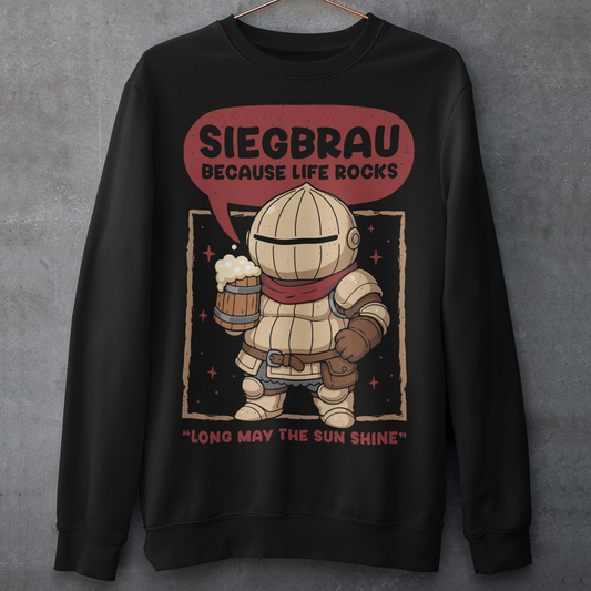Black sweatshirt featuring a cute, chibi-style armored knight Siegmeyer of Catarina holding a frothy beer mug. Above the character, bold text reads “Siegbrau because life rocks,” with smaller text below saying “Long may the sun shine.” The design has a playful fantasy theme with soft red tones and a hand-drawn style, appealing to gamers and fans of medieval or RPG-inspired humor.
