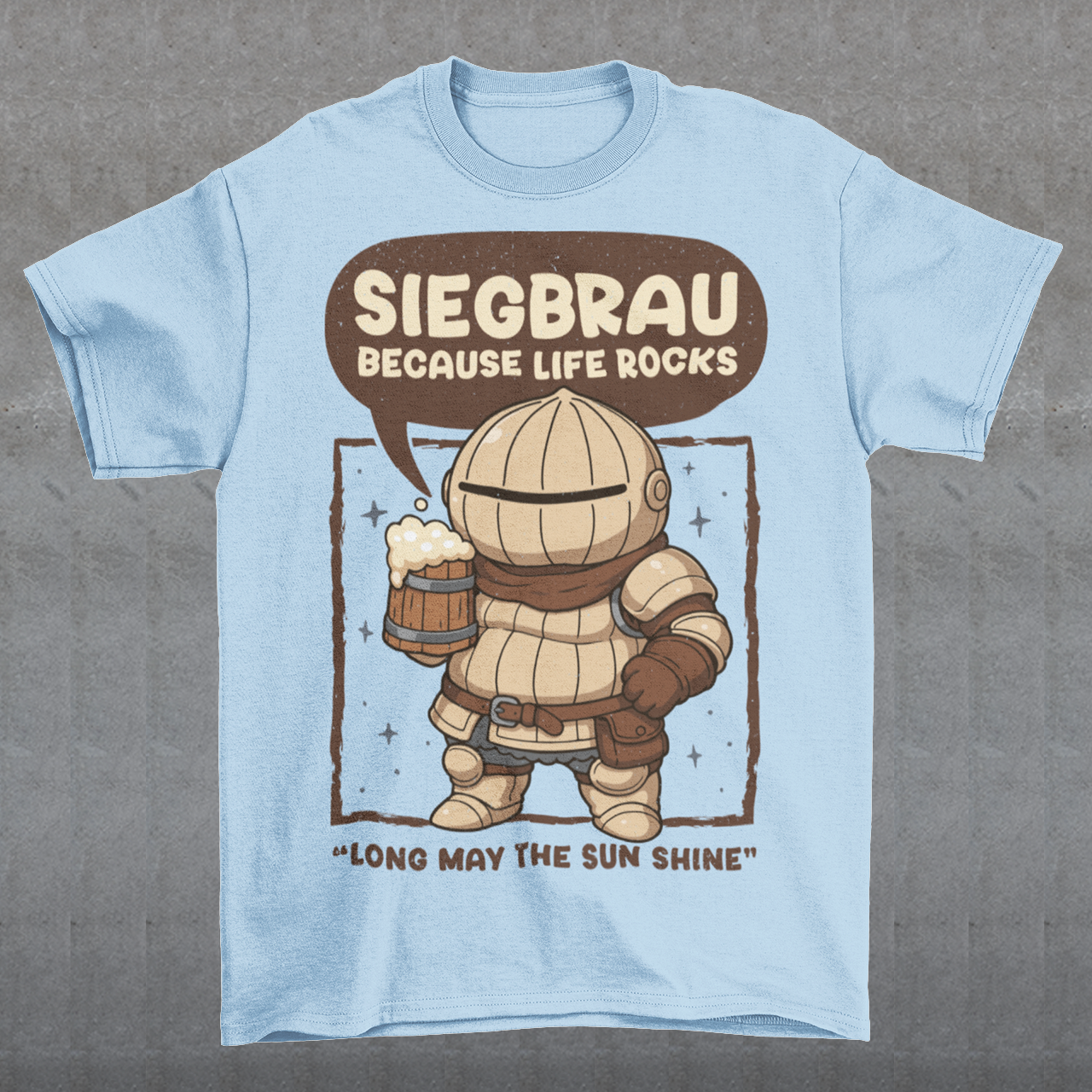 Light blue t-shirt featuring a cute, chibi-style armored knight Siegmeyer of Catarina holding a frothy beer mug. Above the character, bold text reads “Siegbrau because life rocks,” with smaller text below saying “Long may the sun shine.” The design has a playful fantasy theme with soft brown tones and a hand-drawn style, appealing to gamers and fans of medieval or RPG-inspired humor.