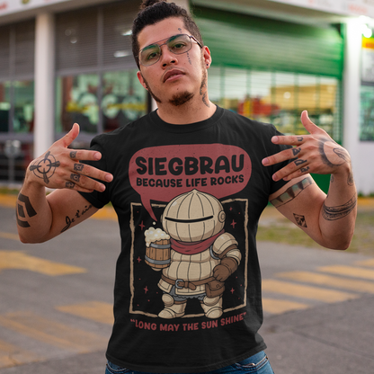 Black t-shirt featuring a cute, chibi-style armored knight Siegmeyer of Catarina holding a frothy beer mug. Above the character, bold text reads “Siegbrau because life rocks,” with smaller text below saying “Long may the sun shine.” The design has a playful fantasy theme with soft red tones and a hand-drawn style, appealing to gamers and fans of medieval or RPG-inspired humor.