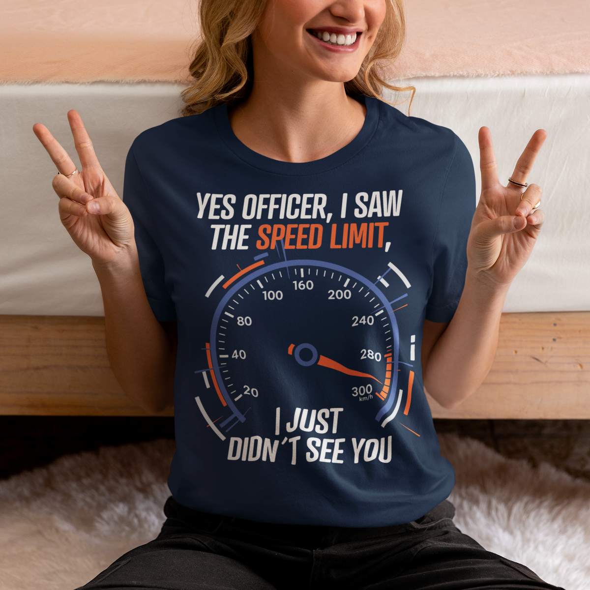 Navy blue t-shirt featuring a bold speedometer graphic with the text “YES OFFICER, I SAW THE SPEED LIMIT, I JUST DIDN’T SEE YOU.” The design uses white, orange, and blue lettering and accents, with a large speed gauge showing speeds up to 300 km/h. Funny driving and car enthusiast themed graphic.