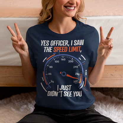 Navy blue t-shirt featuring a bold speedometer graphic with the text “YES OFFICER, I SAW THE SPEED LIMIT, I JUST DIDN’T SEE YOU.” The design uses white, orange, and blue lettering and accents, with a large speed gauge showing speeds up to 300 km/h. Funny driving and car enthusiast themed graphic.