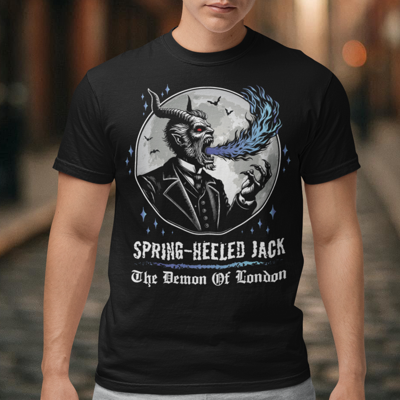 Introducing our electrifying Spring-heeled Jack t-shirt, a striking fusion of folklore and urban legend! Against the backdrop of a hauntingly illuminated moon, Spring-heeled Jack leaps into action, exhaling flames with an otherworldly flair. This enigmatic figure, shrouded in mystery and mischief, has long captured the imagination of Londoners and beyond. With intricate detail and bold colors, our design brings to life the infamous character known as the "Demon of London.