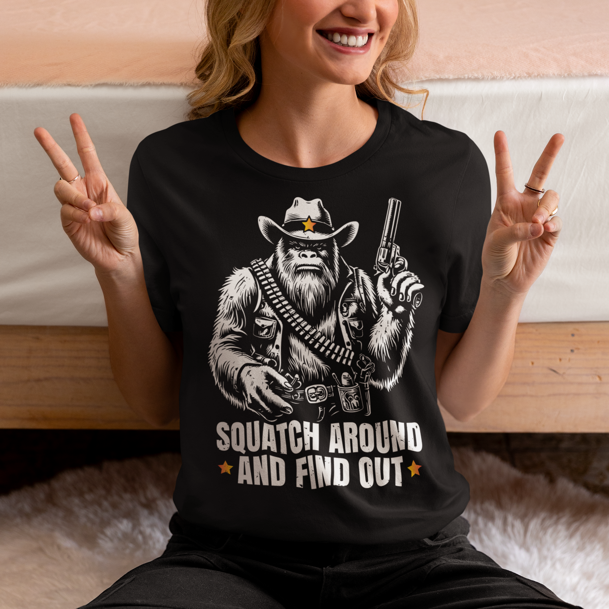 Black t-shirt of a sheriff Sasquatch in the wild west holding a gun with text underneath SQUATCH AROUND AND FIND OUT.