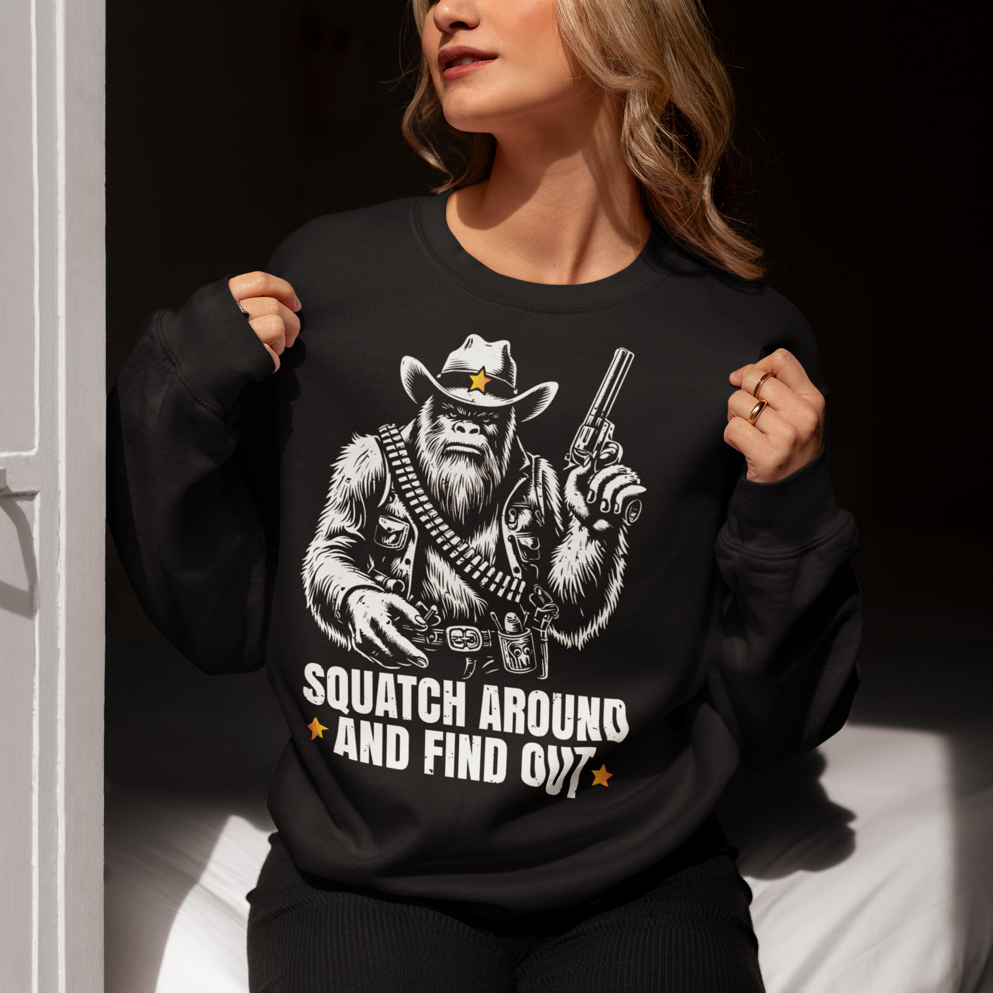 Black sweatshirt of a sheriff Sasquatch in the wild west holding a gun with text underneath SQUATCH AROUND AND FIND OUT.