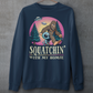 Navy sweatshirt of Bigfoot hiking with an alien in the woods with UFOs in the sky with text underneath SQUATCHIN WITH MY HOMIE.