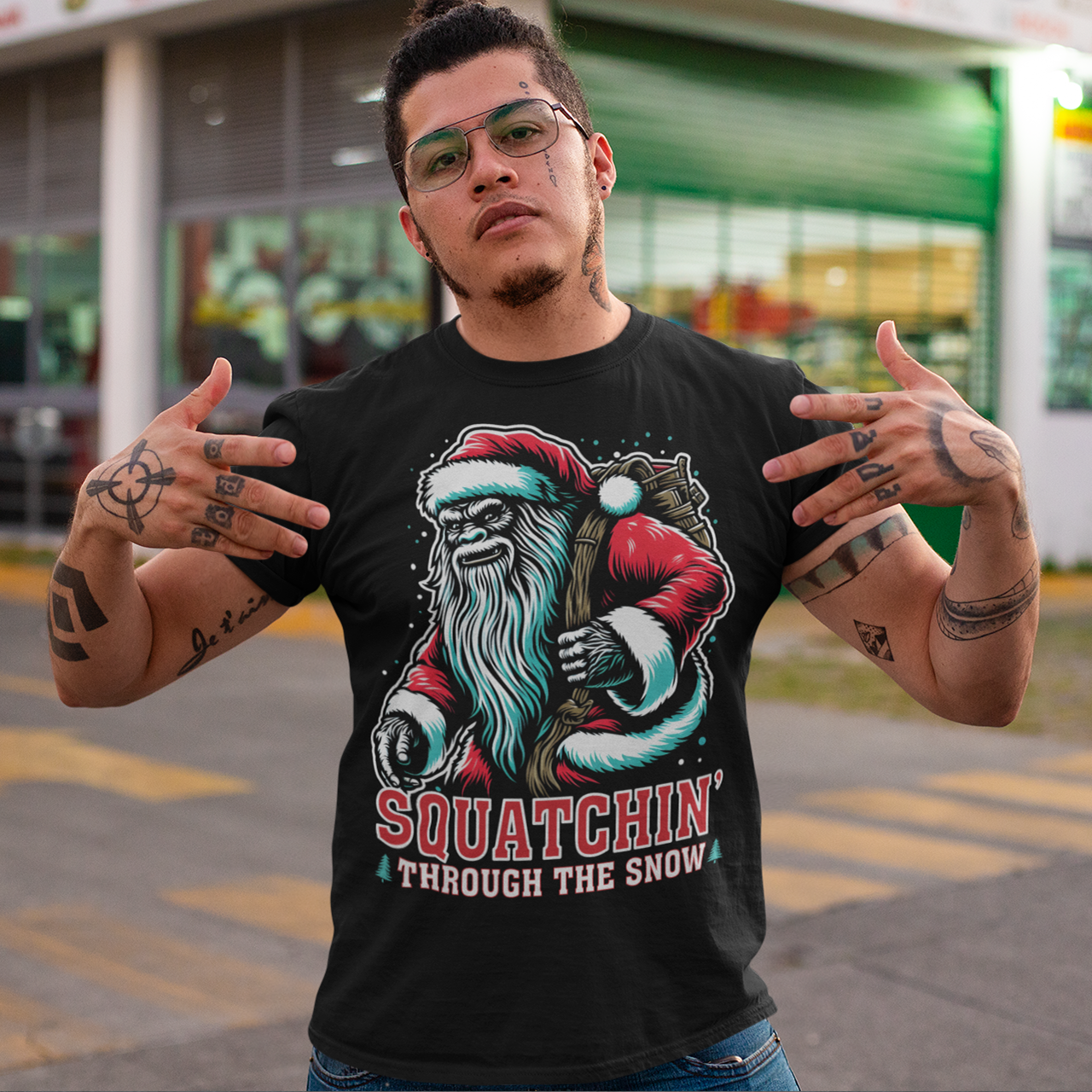 Black Christmas t-shirt of a Santa sasquatch and text "Squatchin' through the snow."