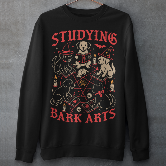 Studying The Bark Arts Sweathirt - Dark Arts Dog Shirt - Dog Lover Top - Funny Pet Gift. Gather the cutest coven you’ve ever seen with this playful and spooky “Studying Bark Arts” sweatshirt. Featuring a circle of adorable pups deep in magical study, this design blends witchy vibes with wholesome dog energy. From tiny spellbooks and glowing candles to pentagrams and wizard hats, every detail adds a charming twist to classic occult imagery, turning dark arts into pure, tail-wagging fun.