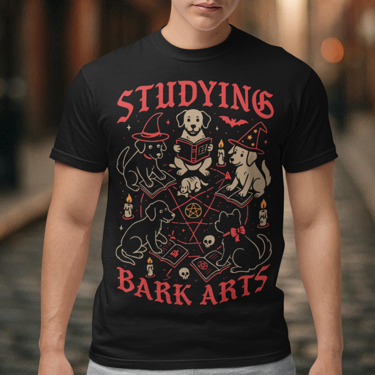 Studying The Bark Arts T-Shirt - Dark Arts Dog Shirt - Dog Lover Tee - Funny Pet Gift. Gather the cutest coven you’ve ever seen with this playful and spooky “Studying Bark Arts” t-shirt. Featuring a circle of adorable pups deep in magical study, this design blends witchy vibes with wholesome dog energy. From tiny spellbooks and glowing candles to pentagrams and wizard hats, every detail adds a charming twist to classic occult imagery, turning dark arts into pure, tail-wagging fun.
