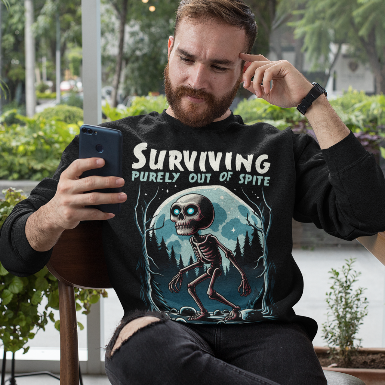 Black sweatshirt of a skeleton skinwalker in a dark forest with text above SURVIVING PURELY OUT OF SPITE.