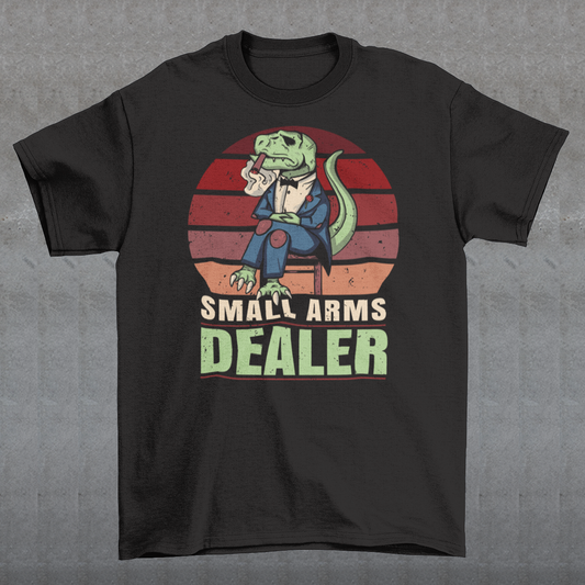 Introducing our one-of-a-kind "Small Arms Dealer" T-shirt, a roaring blend of prehistoric power and modern-day swagger! This tee showcases a whimsical and unforgettable design that's sure to turn heads and spark conversations.
In the heart of the Cretaceous era, meet our mafia T-Rex, dressed to impress in a sleek, pinstriped suit. With a cigar perched confidently between his tiny T-Rex teeth, he exudes an air of authority and a touch of humor.