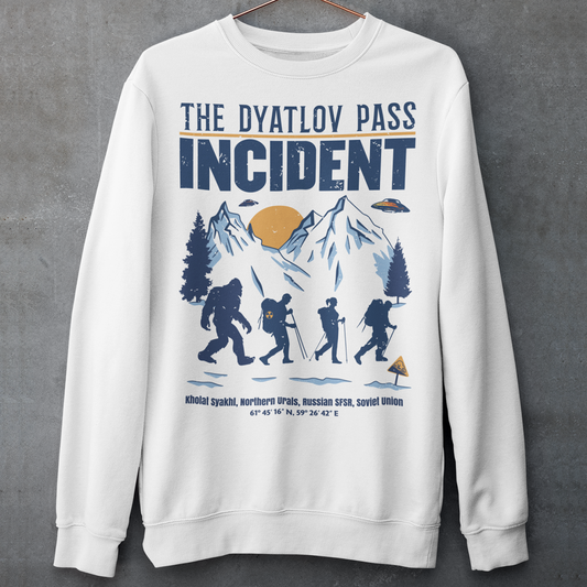 White sweatshirt of 3 hikers including Bigfoot in snowy mountains with UFOs and text THE DYATLOV PASS INCIDENT.