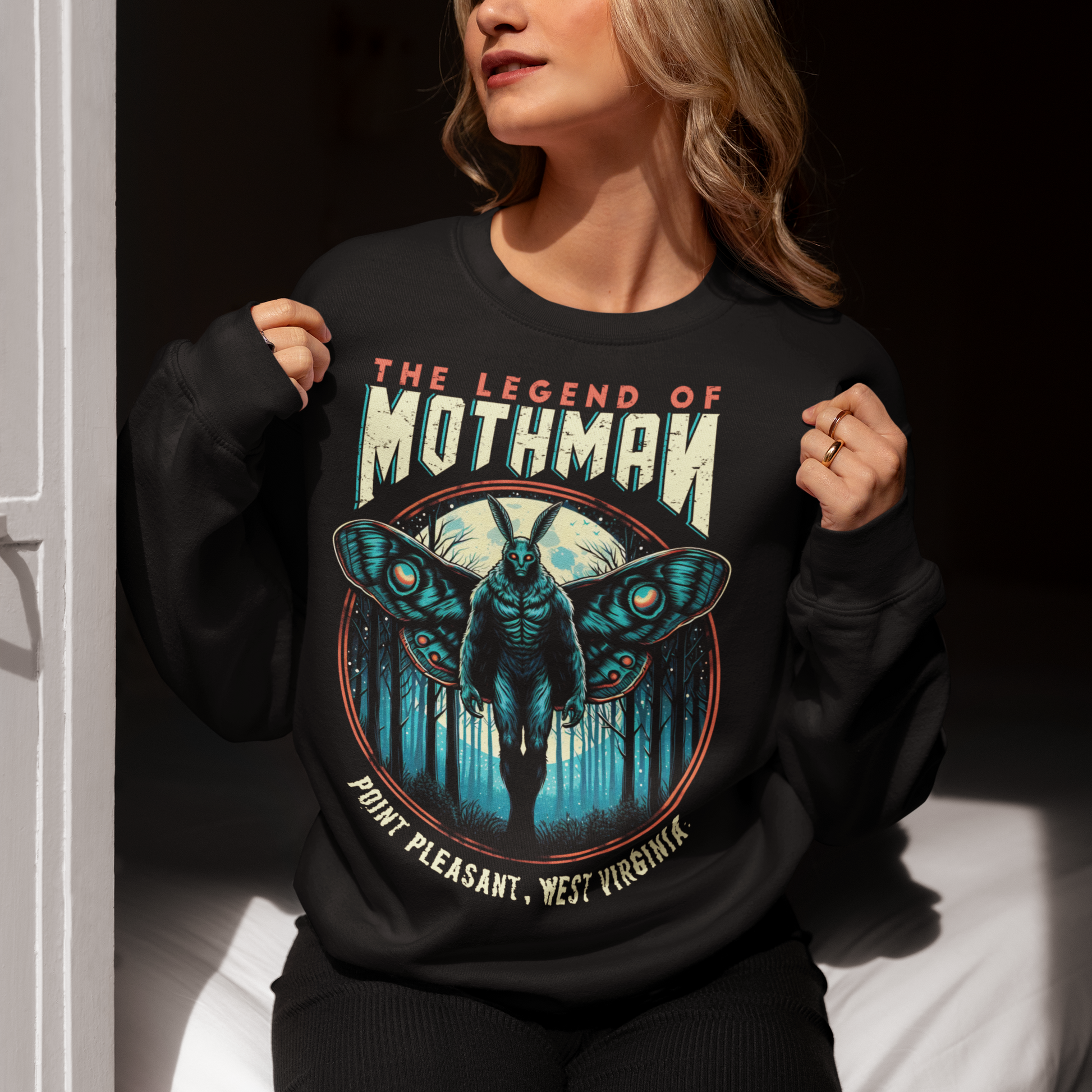 Black sweatshirt of Mothman in a forest with text above THE LEGEND OF MOTHMAN.