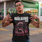 Black t-shirt of a zombie walking a dog in the apocalypse with text above THE WALKING DOG and text below POST-APOCALYPTIC DOG WALKER.