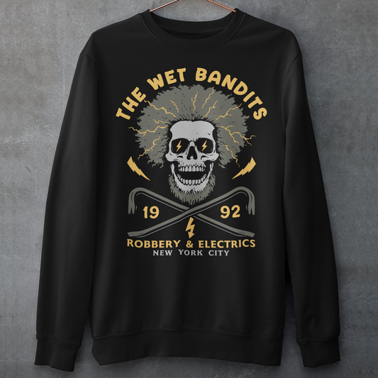Shock your style to life with this “The Wet Bandits – Robbery And Electrics” sweatshirt! Featuring a bold skull design with wild electric hair, crossed crowbars, and vintage lettering, this tee blends rock-n-roll attitude with classic movie nostalgia. Inspired by the unforgettable duo from the holiday favorite, it’s perfect for fans who love edgy humor and retro vibes.