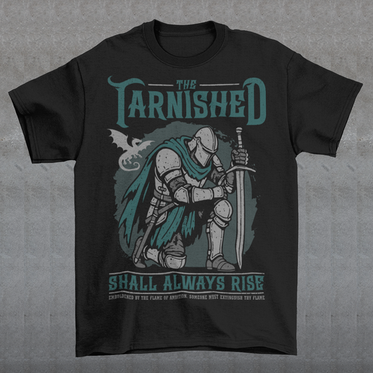 Black t-shirt featuring a dark fantasy design of a kneeling armored knight holding a sword with teal accents and a dragon silhouette in the background. Large text reads “The Tarnished Shall Always Rise,” with smaller medieval-style text underneath. Inspired by fantasy RPG and soulslike gaming aesthetics.
