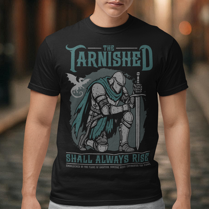 Black t-shirt featuring a dark fantasy design of a kneeling armored knight holding a sword with teal accents and a dragon silhouette in the background. Large text reads “The Tarnished Shall Always Rise,” with smaller medieval-style text underneath. Inspired by fantasy RPG and soulslike gaming aesthetics.