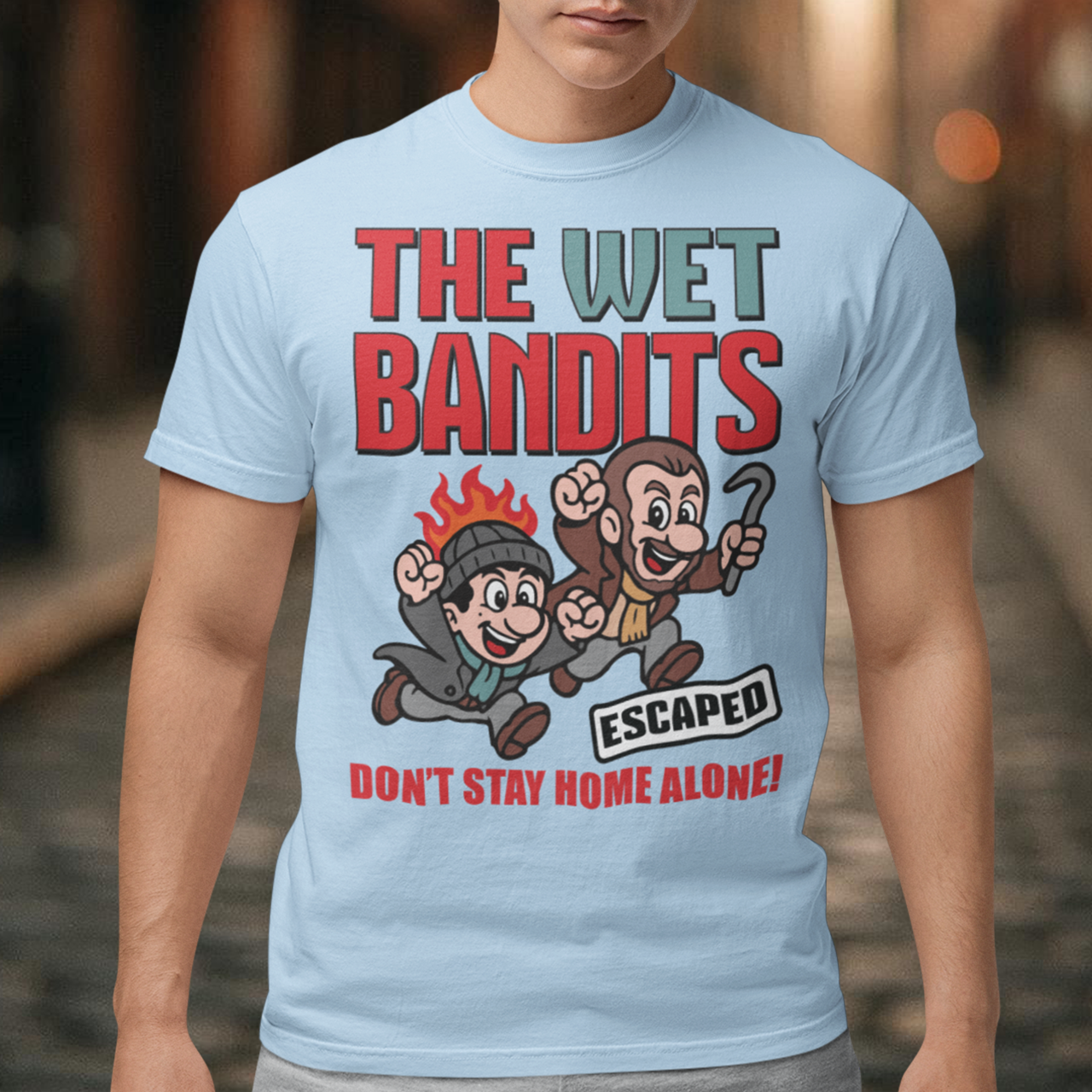Bring some nostalgic mischief to your wardrobe with this “The Wet Bandits – Don’t Stay Home Alone!” t-shirt! Inspired by the classic holiday comedy, this fun retro-style design features a cartoon version of the iconic burglar duo in bold, vintage colors. Perfect for fans of 90s movies, Christmas classics, and throwback humor, this shirt blends playful artwork with cozy comfort.