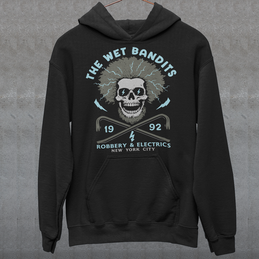 Shock your style to life with this “The Wet Bandits – Robbery And Electrics” hoodie! Featuring a bold skull design with wild electric hair, crossed crowbars, and vintage lettering, this tee blends rock-n-roll attitude with classic movie nostalgia. Inspired by the unforgettable duo from the holiday favorite, it’s perfect for fans who love edgy humor and retro vibes.