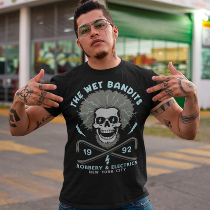 Shock your style to life with this “The Wet Bandits – Robbery And Electrics” t-shirt! Featuring a bold skull design with wild electric hair, crossed crowbars, and vintage lettering, this tee blends rock-n-roll attitude with classic movie nostalgia. Inspired by the unforgettable duo from the holiday favorite, it’s perfect for fans who love edgy humor and retro vibes.