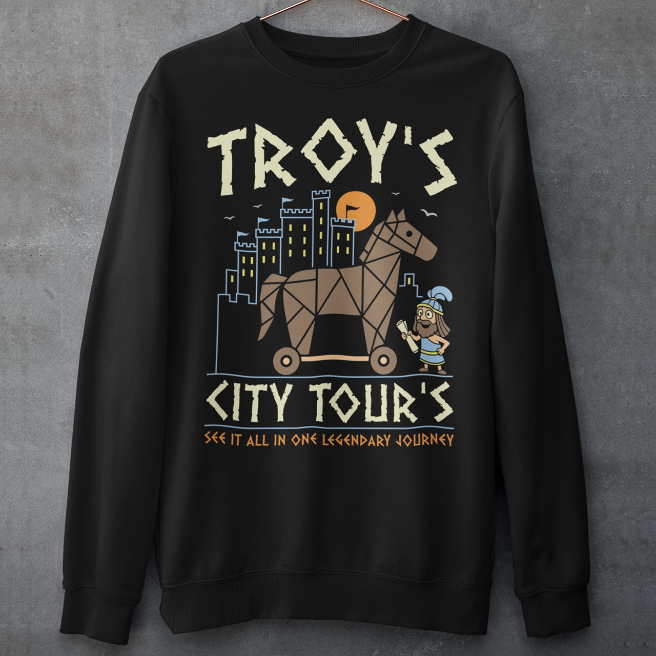 Black sweatshirt featuring a colorful “TROY’S CITY TOURS” graphic with a stylized Trojan horse rolling through an ancient city at sunset. The design includes a small cartoon Trojan warrior and the phrase “SEE IT ALL IN ONE LEGENDARY JOURNEY.” A fun ancient history and Greek mythology themed shirt for history buffs, mythology fans, travelers, and archaeology enthusiasts.