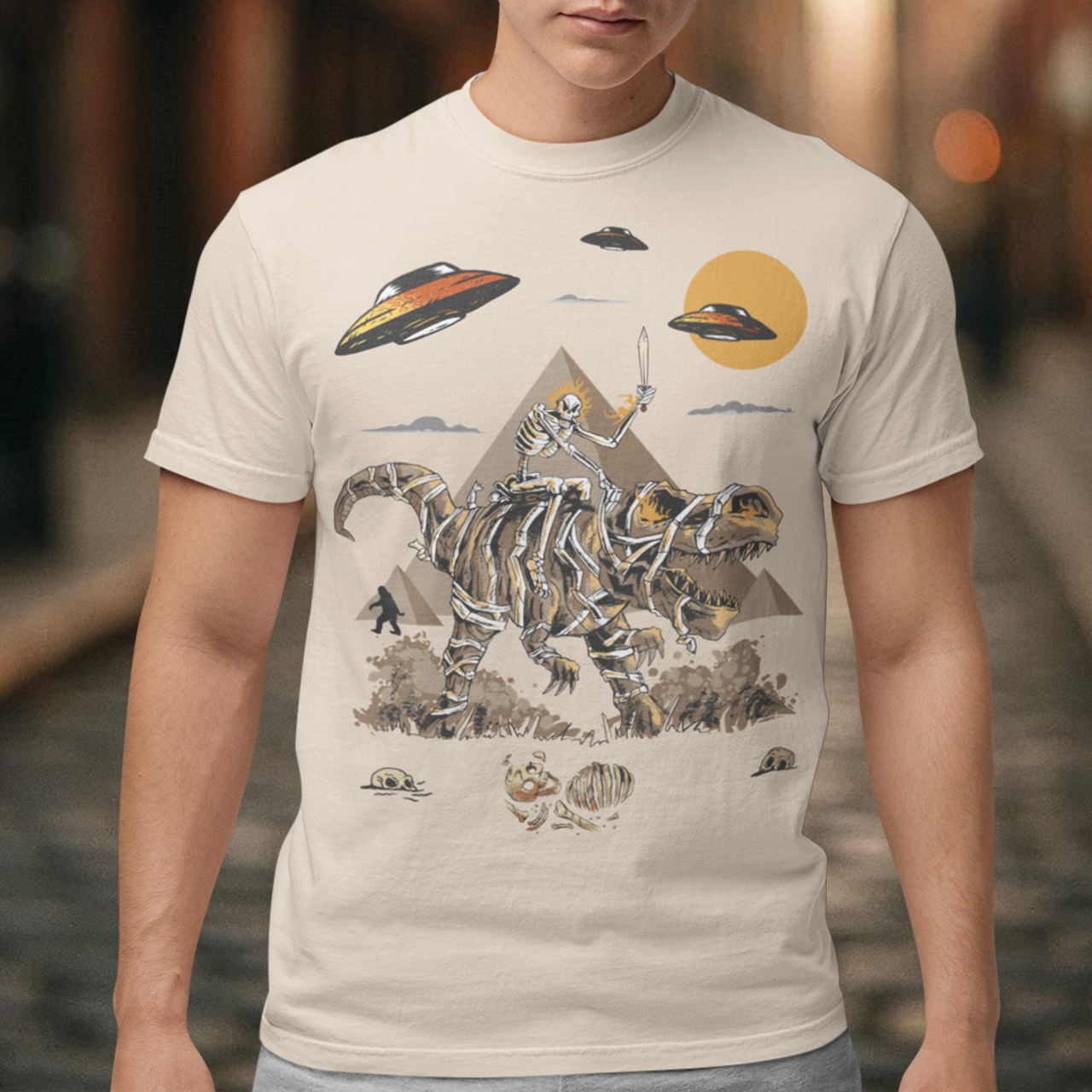 Get ready to embark on an epic adventure with our mind-blowing t-shirt design! Picture this: a skeleton riding a T-Rex through the ancient wonders of Egypt, with UFOs hovering in the sky and Bigfoot mysteriously lurking in the background. It's a jaw-dropping fusion of history, mythology, and the unknown, all beautifully captured in one captivating design.