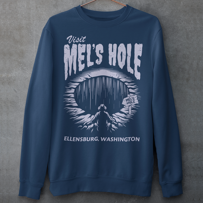 Step into the strange with this quirky and mysterious shirt! Featuring a bold illustration of a curious man peering into a dark, bottomless abyss, this shirt pays homage to the legendary paranormal tale of&nbsp;Mel's Hole — a supposed infinite pit in the wilds of Washington State. The vintage-style artwork is topped with the eerie invitation: "VISIT MEL'S HOLE" in retro tourism font, blending humor, folklore, and a dash of the unexplained.