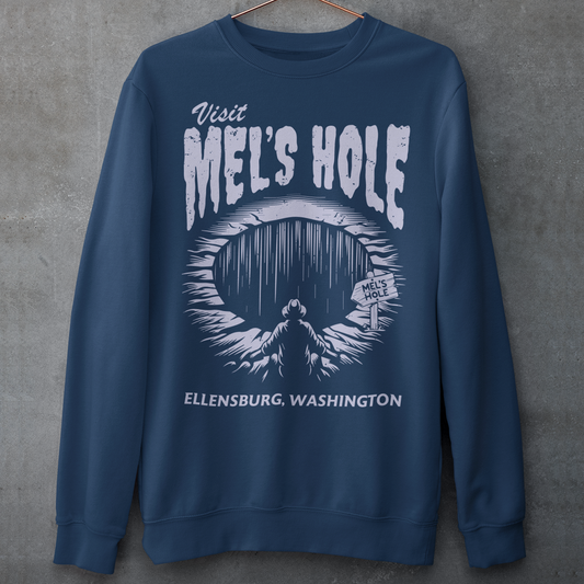 Step into the strange with this quirky and mysterious shirt! Featuring a bold illustration of a curious man peering into a dark, bottomless abyss, this shirt pays homage to the legendary paranormal tale of&nbsp;Mel's Hole — a supposed infinite pit in the wilds of Washington State. The vintage-style artwork is topped with the eerie invitation: "VISIT MEL'S HOLE" in retro tourism font, blending humor, folklore, and a dash of the unexplained.
