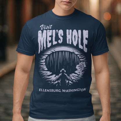 Step into the strange with this quirky and mysterious tee! Featuring a bold illustration of a curious man peering into a dark, bottomless abyss, this shirt pays homage to the legendary paranormal tale of Mel's Hole — a supposed infinite pit in the wilds of Washington State. The vintage-style artwork is topped with the eerie invitation: "VISIT MEL'S HOLE" in retro tourism font, blending humor, folklore, and a dash of the unexplained.
