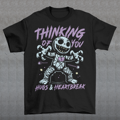 Dark humor meets twisted sweetness with this bold tee. Featuring a stitched-up voodoo doll at the center, the design captures that perfect mix of love and pain. Above the doll, the phrase “THINKING OF YOU” adds a playful sting, while below, “HUGS & HEARTBREAK” ties it all together with equal parts irony and affection. Perfect for anyone who loves edgy, alternative fashion—or just wants to send a cheeky message without saying a word.