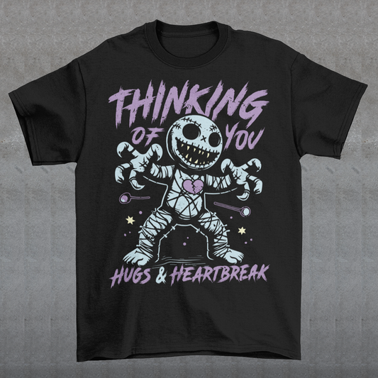 Dark humor meets twisted sweetness with this bold tee. Featuring a stitched-up voodoo doll at the center, the design captures that perfect mix of love and pain. Above the doll, the phrase “THINKING OF YOU” adds a playful sting, while below, “HUGS & HEARTBREAK” ties it all together with equal parts irony and affection. Perfect for anyone who loves edgy, alternative fashion—or just wants to send a cheeky message without saying a word.