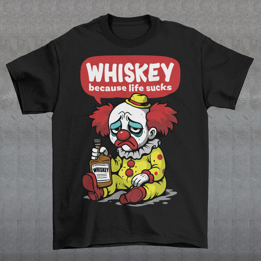 Black t-shirt featuring a sad cartoon clown with messy red hair and a tired expression, sitting on the ground holding a bottle labeled whiskey. Above the character, bold text reads “Whiskey because life sucks.” The design combines dark humor with a playful cartoon style, creating a sarcastic and slightly edgy visual.