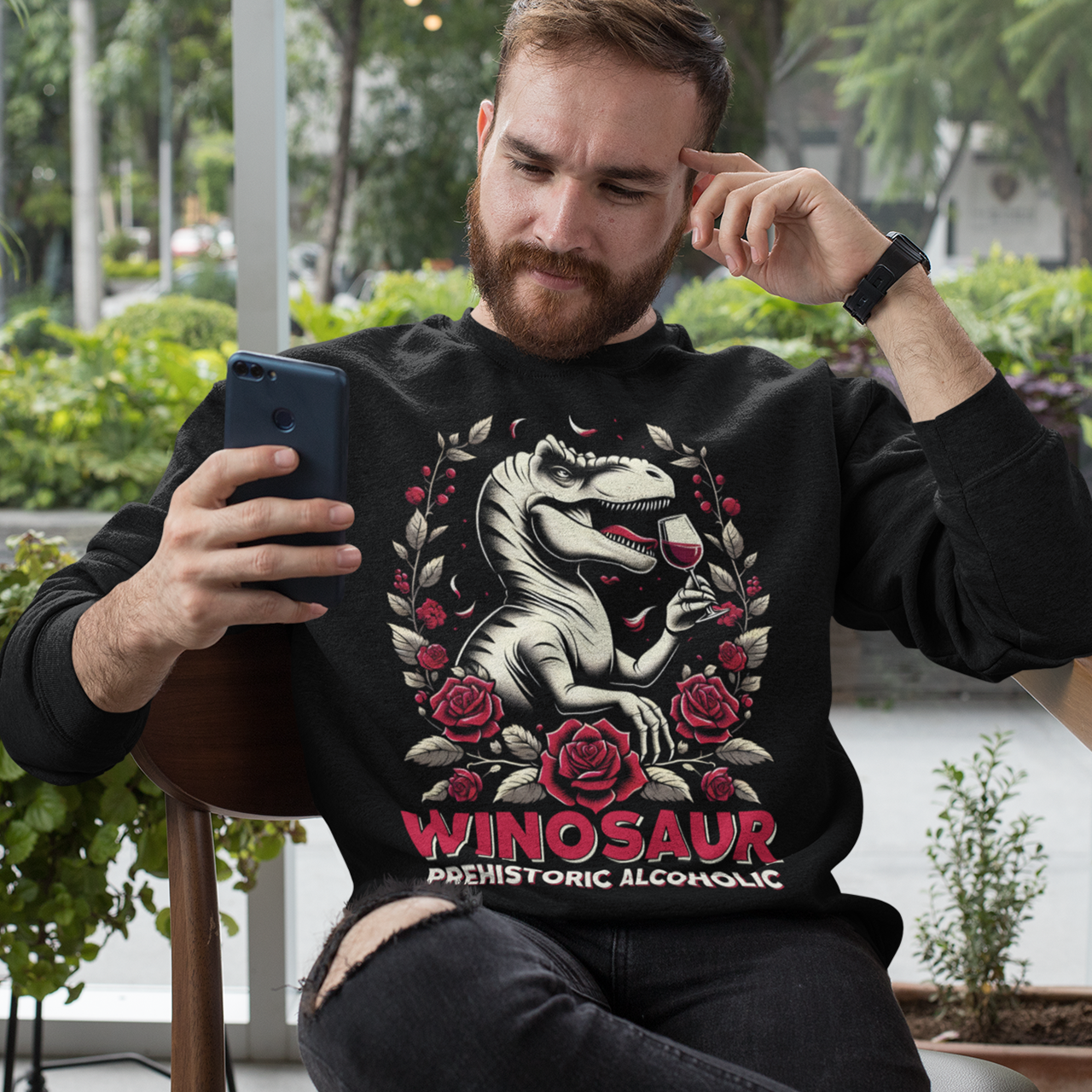 Black sweatshirt of a T-Rex drinking wine with text below WINOSAUR PREHISTORIC ALCOHOLIC.