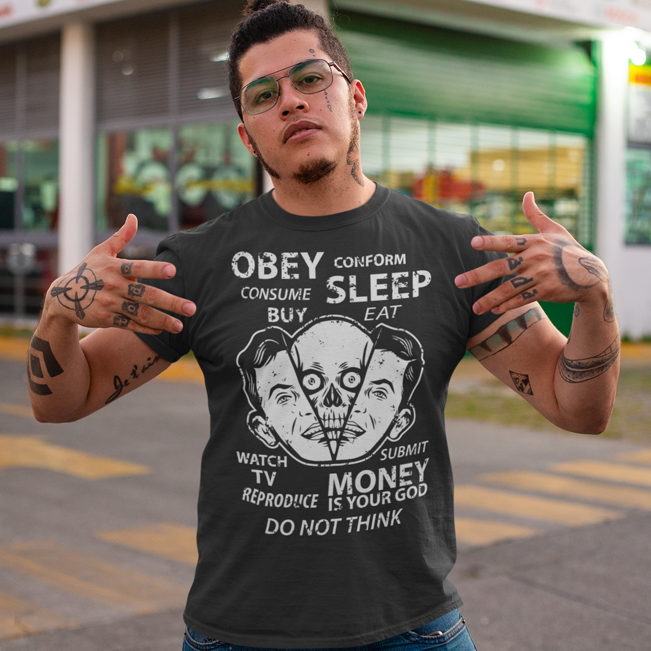 Black t-shirt with alien emerging from a head with text "OBEY, CONFORM, CONSUME, SLEEP, WATCH TV, MONEY IS YOUR GOD".